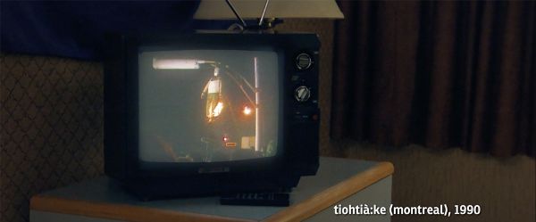 An image of a burning effigy on an old TV set screen. The bottom right states “tiohtià:ke (montreal), 1990.”